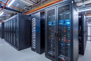 Rows of active server racks with multicolored indicator lights in a secure; climate-controlled data center facility.